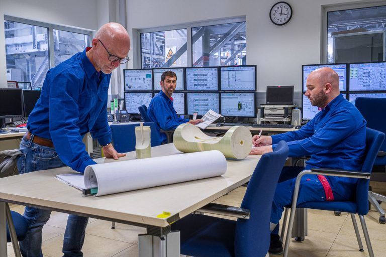 Fotografia industrial de operarios con planos en la sala de control de la empresa Dupont