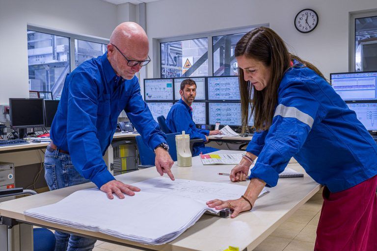 Fotografia industrial de operarios con planos en la sala de control de la empresa Dupont
