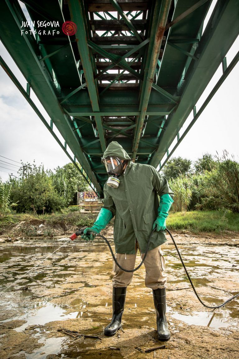 Fotografia industrial operario realizando mantenimiento en el rio francoli de Tarragona bajo puente ferrocarril para empresa SAHICASA dedicada a control de plagas