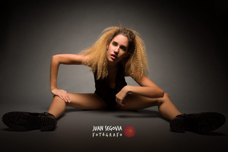 Fotografia de moda con la modelo Nerea Arroyo sentada en el suelo en body negro y pose rota por el fotografo Juan Segovia en el estudio fotografico de Punt de Vista
