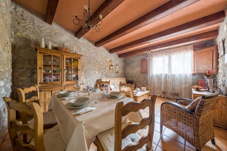 Fotografia del salon, comedor con mesa y atrezzo en el la casa rural Lo maset de Carmeta en Tivenys, Tarragona