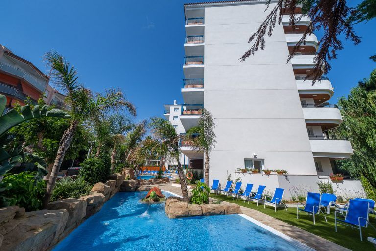 Piscina con hamacas y fachada trasera en apartamentos Ancora de Salou Tarragona