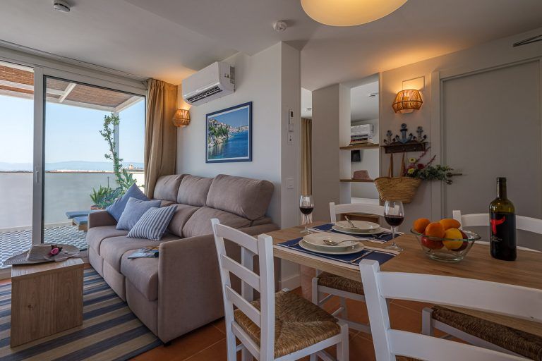 Salon comedor con mesa montada con almuerzo en apartamentos Ancora de Salou Tarragona