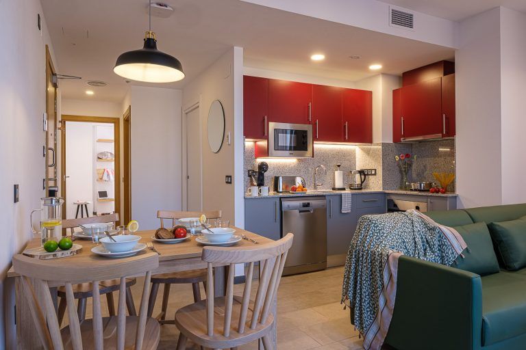 Fotografía de apartamentos turísticos. Salon comedor y cocina con atrezzo en apartamento Real de Tarragona