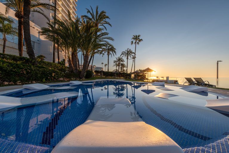Amanecer con tumbonas sumergidas en la piscina del hotel Torrequebrada de Málaga